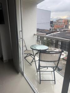 a table and chairs on a balcony with a view at En el corazon de Dosquebradas in Dosquebradas
