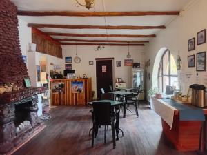 a living room with tables and chairs and a fireplace at CaminAndes Hostal in San Pedro de Atacama