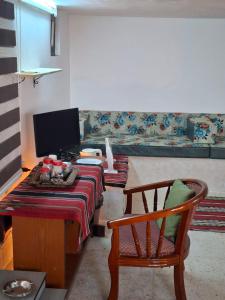 a living room with a couch and a table and a chair at Mountain Pad Overlooking Jerash - HQ Budget stay in Jerash