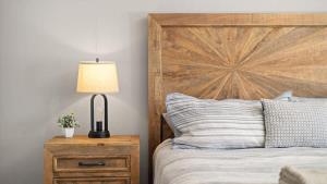 a bed with a wooden headboard and a lamp on a night stand at Altitude Adjustment in Red Lodge