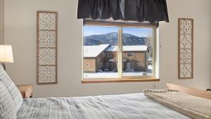 a bedroom with a window with a view of a house at Altitude Adjustment in Red Lodge