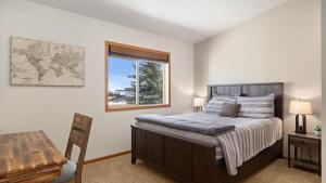 a bedroom with a bed and a desk and a window at Altitude Adjustment in Red Lodge +36 photos