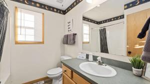 a bathroom with a sink and a toilet and a mirror at Mountain View Villa in Red Lodge