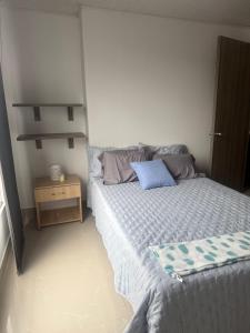 a bedroom with a bed with a blue pillow on it at En el corazon de Dosquebradas in Dosquebradas