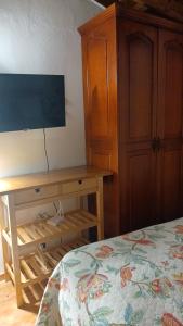 a bedroom with a bed and a wooden desk at Doña Mayra Aparta Hotel, Rustico in Las Terrenas
