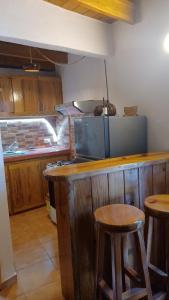 a kitchen with a counter with stools and a stove at Doña Mayra Aparta Hotel, Rustico in Las Terrenas
