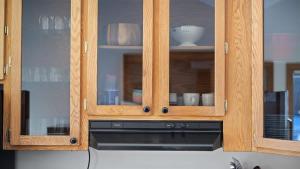 a kitchen with wooden cabinets with dishes in it at Grizzly Grotto in Red Lodge