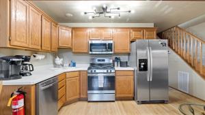 a kitchen with wooden cabinets and stainless steel appliances at Putter`s Inn in Red Lodge +30 photos