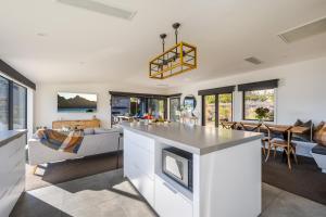 an open kitchen and living room with a fireplace at Blackwood Lakeview Retreat in Queenstown
