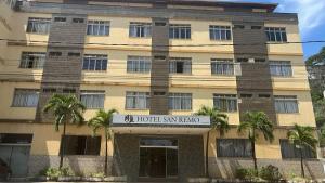 a hotel akarmaarma building with a sign in front of it at Hotel San Remo in Ubá