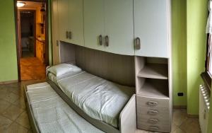 a bed in a room with green walls and white cabinets at Residence Future in Cologno Monzese +4 photos