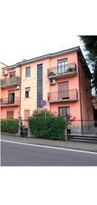 a large pink building with balconies on a street at Residence Future in Cologno Monzese