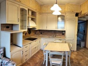 a kitchen with white cabinets and a table and chairs at Residence Future in Cologno Monzese