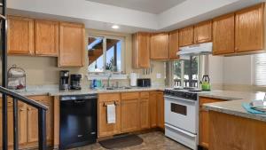 a kitchen with wooden cabinets and a black and white appliance at Sans Souci Cabin in Red Lodge