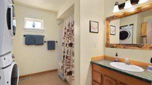 a bathroom with a sink and a washer and dryer at Sans Souci Cabin in Red Lodge +43 photos