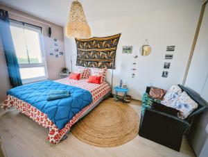 a bedroom with a bed and a chair in it at La Villa Bleue in Beauchastel