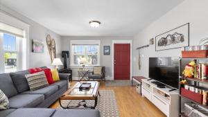 a living room with a gray couch and a red door at Alpine Adventure in Red Lodge