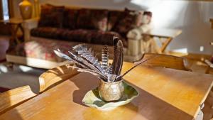 a vase on a table with a plant on it at Chickadee Chalet in Red Lodge