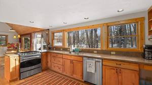 a kitchen with wooden cabinets and a stove top oven at Chickadee Chalet in Red Lodge