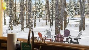 a window with chairs and a table in the snow at Chickadee Chalet in Red Lodge