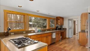 a kitchen with wooden cabinets and a stove top oven at Chickadee Chalet in Red Lodge +36 photos