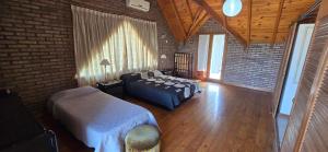 a bedroom with a bed and a couch and a brick wall at Chalet Nuevo Amanecer in Merlo +27 photos