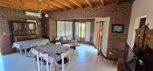 a room with two tables and chairs and a brick wall at Chalet Nuevo Amanecer in Merlo