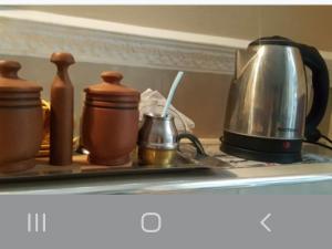 a tray with pots and a tea kettle on a shelf at Habitación con baño privado in La Plata