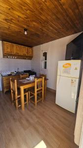 a kitchen with a table and a white refrigerator at Hospedaje J & L in Uspallata