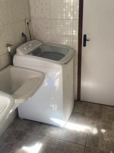 a bathroom with a toilet and a tub next to a door at Flat Aeroporto - Estrada do coco - Lauro de Freitas M in Lauro de Freitas