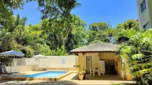 a villa with a swimming pool and a house at Flat Aeroporto - Estrada do coco - Lauro de Freitas M in Lauro de Freitas