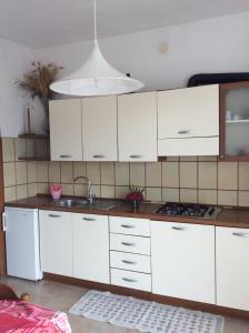 a kitchen with white cabinets and a sink at La Salina in Lampedusa +74 photos