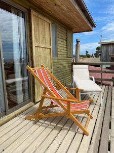 a rocking chair and a white chair on a deck at Cómoda Casa Con Vista al Mar in El Cerrillo