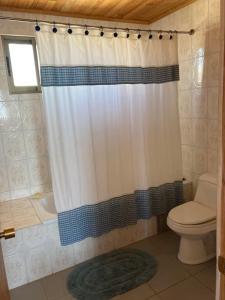 a bathroom with a shower curtain and a toilet at Cómoda Casa Con Vista al Mar in El Cerrillo +14 photos