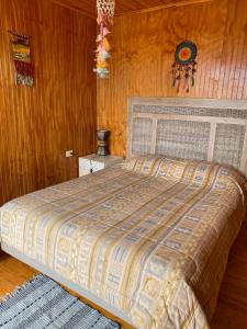 a bedroom with a bed and a wooden wall at Cómoda Casa Con Vista al Mar in El Cerrillo