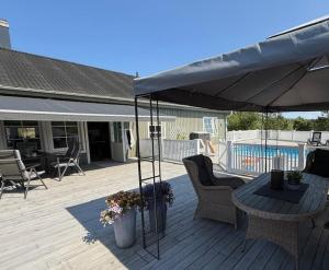 a patio with an umbrella and a table and chairs at Ditt feriehjem! in Kristiansand
