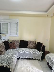 a living room with a couch and a window at Casa de 1 quarto in Torres