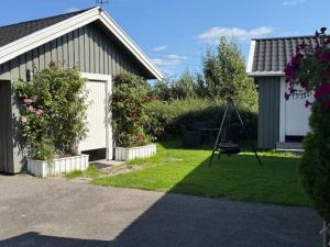 a yard with a house and a swing at Ditt feriehjem! in Kristiansand