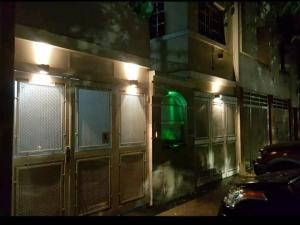 a building with doors with a green light on it at Habitación con baño privado in La Plata