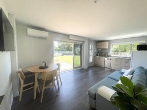 a living room with a blue couch and a table at Beachside Bliss - freshly renovated in Napier
