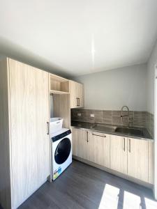 a kitchen with a sink and a dishwasher at Beachside Bliss - freshly renovated in Napier