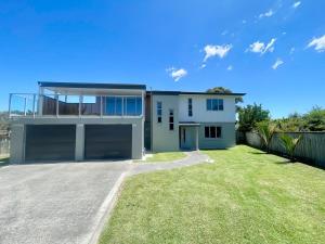 a house with a large yard in front of it at Beachside Bliss - freshly renovated in Napier