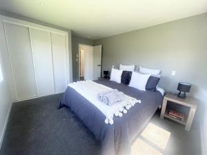 a bedroom with a bed with two towels on it at Beachside Bliss - freshly renovated in Napier