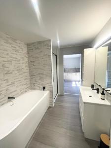 a white bathroom with two sinks and a tub at Beachside Bliss - freshly renovated in Napier +22 photos
