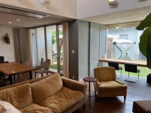 a living room with a couch and chairs and a table at Urara Holiday in Sumoto