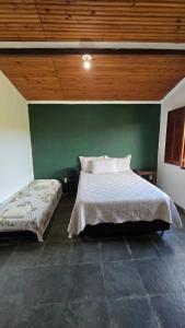 a bedroom with a bed and a green wall at Excelente Sitio em Juatuba in Juatuba +21 photos