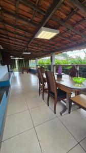 a patio with a wooden table and chairs at Excelente Sitio em Juatuba in Juatuba