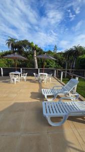 a group of white chairs and tables with umbrellas at Excelente Sitio em Juatuba in Juatuba