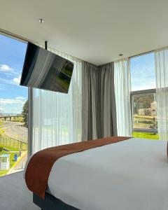 a bedroom with a large bed and a large window at Hotel B3 Sibelius in Chía