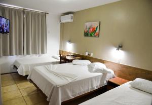 a hotel room with two beds and a window at Santa Maria Hotel in Cascavel